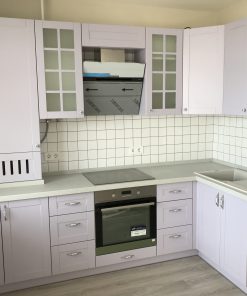 белая кухня с черным духовым шкафом и оливковыми обоями